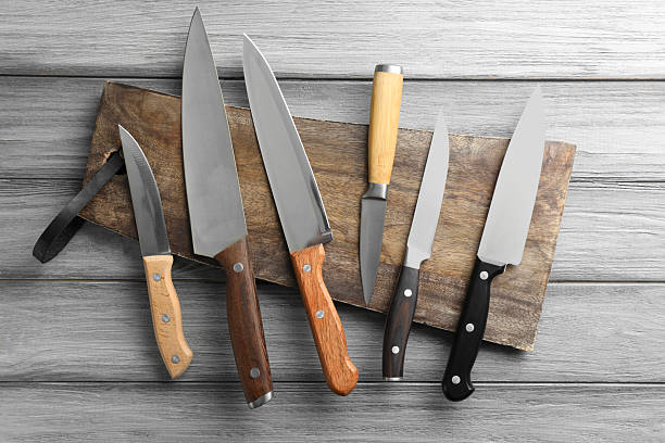 istock Many different knives and board on light wooden table, flat lay 2252592587