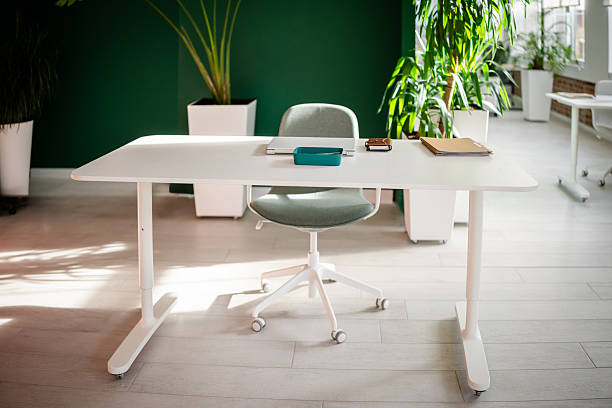 istock Modern office workspace with a desk, chair, and plants during daytime 2252595736