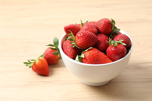 istock Delicious fresh red strawberries in a bowl on a light background 2252598786