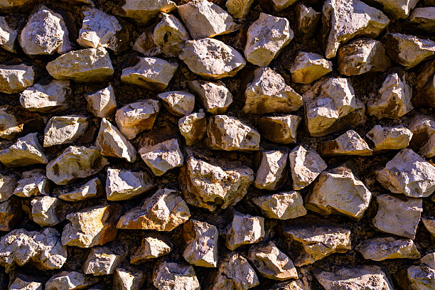 Stone wall with rustic texture. Old brick wall in historic building. Natural stone surface background. Textured stone facade in architecture. Stone blocks forming building wall