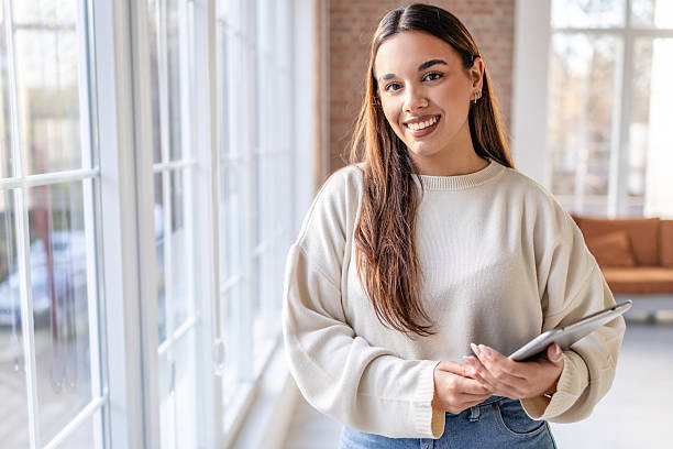 istock Professional woman holds tablet in modern office while engaging in work with colleagues during business hours 2252601416