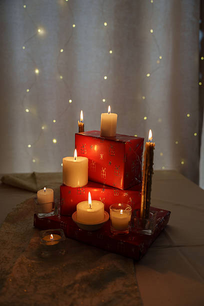 istock warm holiday ambiance with glowing candles atop red gift boxes adorned with shiny present patterns 2252602576