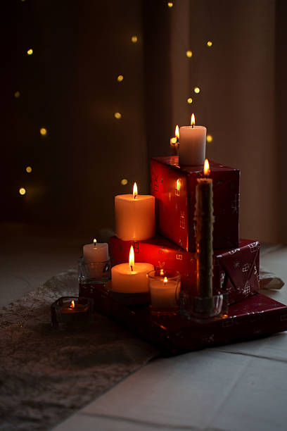 istock warm and cozy ambiance with flickering candlelight on stacked red gift boxes amidsoft glowing bokeh background 2252602583