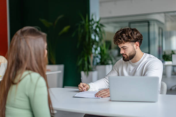 istock Two adults engage in a work-related discussion in a modern office setting during daytime hours 2252604021
