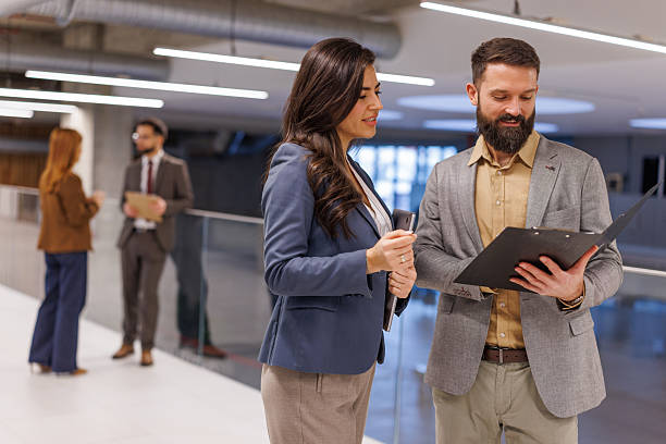 istock Business people collaborating discussing work in modern office hallway 2252605356