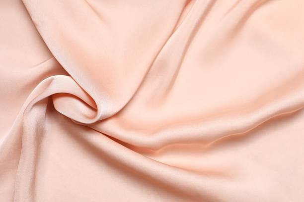 istock Beige silk satin. Shiny smooth fabric. Soft folds. Luxury background with space for design. Flat table, top view 2252606579