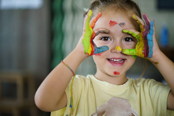 istock Happy child playing with colorful paint on hands. 2252607330