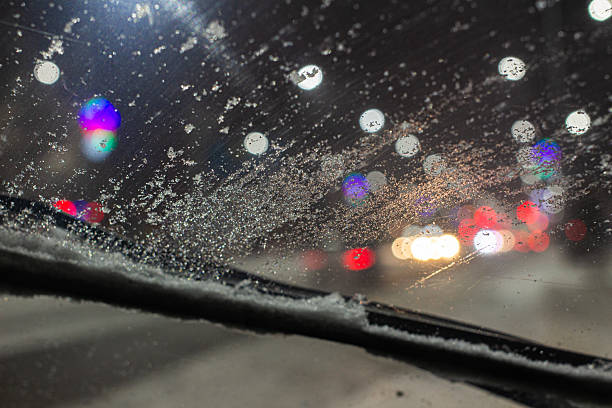 istock An icy windshield wiper that doesn't clear snow and ice well, obscuring visibility while driving on the highway, and the danger of driving in poor visibility. 2252607492