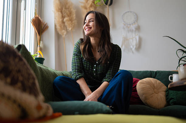 istock Young woman relaxing on sofa at home smiling happily 2252608691