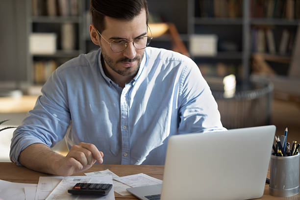 istock Millennial businessman paying bills online via bank app on notebook 2252609080