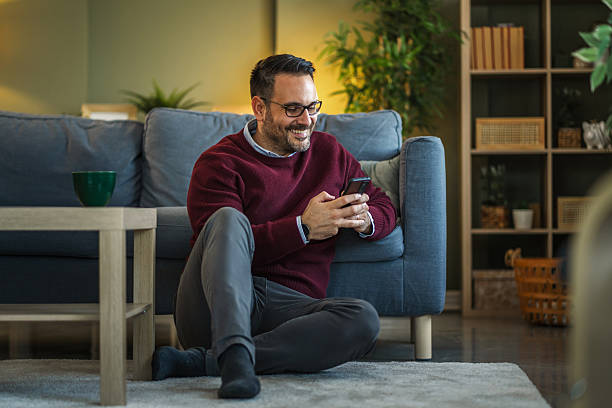 istock Man relaxing home using smart phone in living room 2252609240