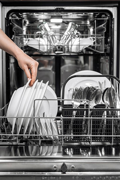 istock Dishwasher loaded with clean dishes, including plates, glasses 2252609294