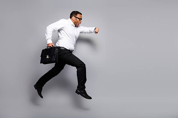 istock Energetic businessman jumps in air with briefcase in studio 2252610072