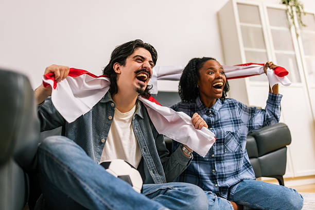 istock Multiracial Couple Cheering Soccer at Home 2252616202