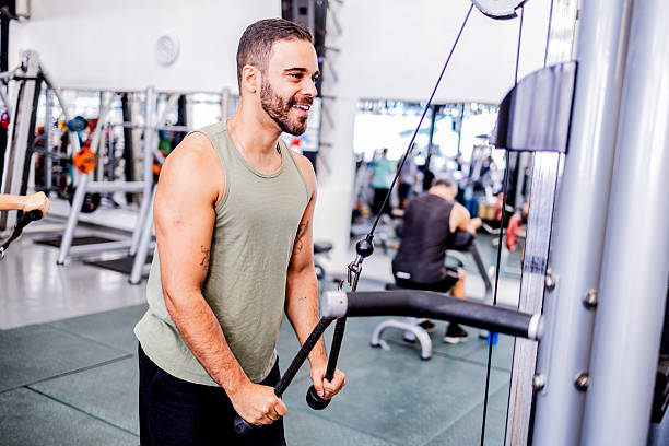 istock Mid adult man doing triceps exercise on pulley machine at gym 2252616815