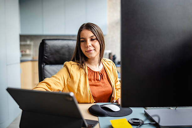 istock Colleague works at desk in office using tablet and computer during daytime hours 2252620657