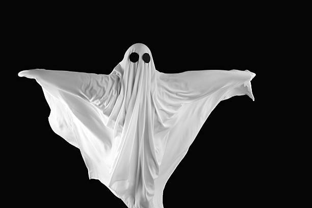 Creepy ghost. Person covered with white sheet on black background