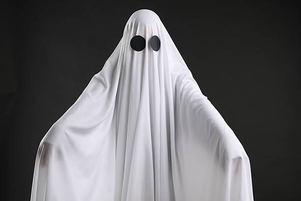 istock Creepy ghost. Person covered with white sheet on black background 2252629266