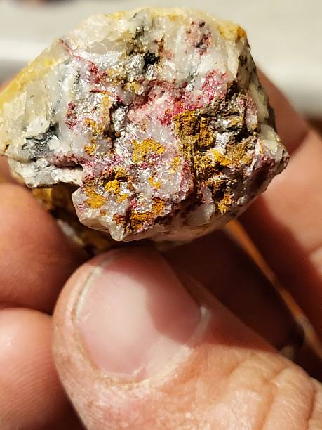 istock Fingers Holding a Rock Sample Containing Cinnabar 2252632432