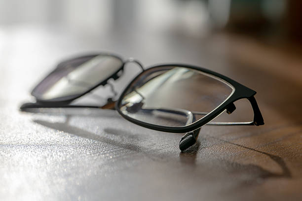 istock Black rimmed eyeglasses on wooden table in sunlight 2252632975