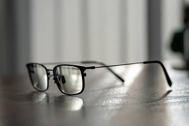 istock Black rimmed eyeglasses on wooden table in sunlight 2252633044