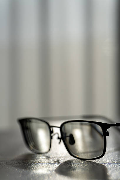 istock Black rimmed eyeglasses on wooden table in sunlight 2252633054