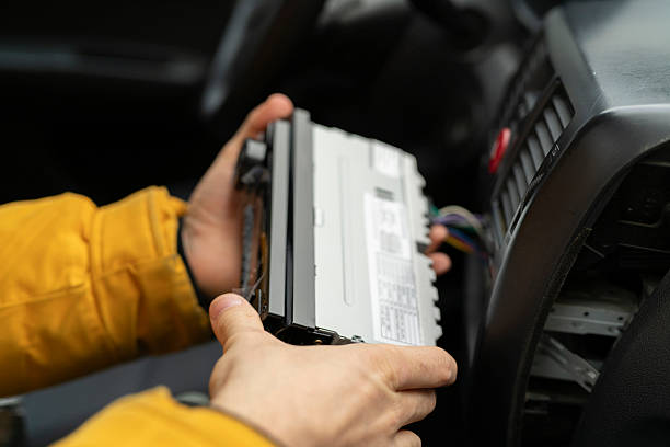 istock A person works on a car audio system in a garage while removing the unit from the dashboard 2252633309
