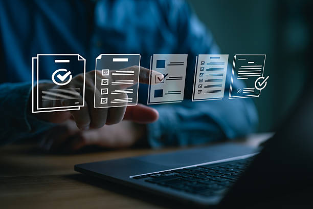 istock Businessman using a laptop to select digital checklist icons, representing task management, document completion, productivity, workflow organization, and online form processing. 2252641015