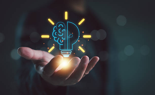 istock New ideas and inspiration concept, Hand holding drawing virtual lightbulb with brain on dark background for creative and smart thinking idea concept. 2252641503
