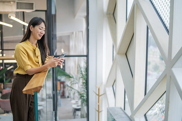 istock Young asian businesswoman using smartphone in modern office 2252643426