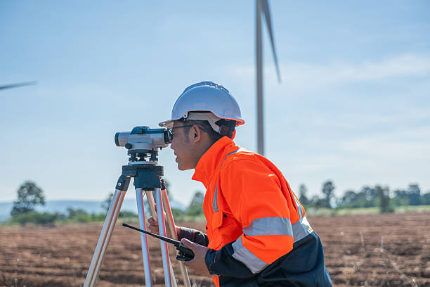 istock Engineer working at renewable energy site wind turbines examining  blueprint surveying instrument mounted tripod ensuring accurate land measurements practices in environmental industrial. 2252645314