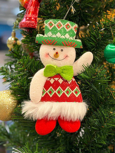 Stock photo shows christmas tree adorned with handmade felt fabric snowman ornaments, showcasing intricate crafting and DIY holiday decorations. Perfect for seasonal décor, craft inspiration, social media visuals, greeting cards, festive interiors