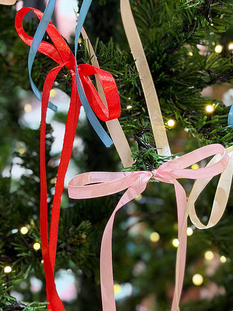istock Image of artificial christmas tree with realistic needles featuring pink and red ornaments, decorative ribbons and bows 2252647270