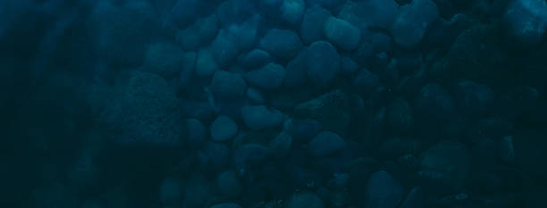 istock dark blue pebbles on the river bottom, top view 2252650294