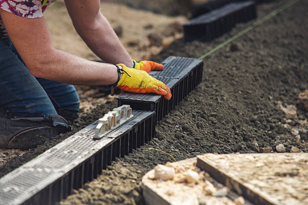 istock Person laying drainage channels by hand on  construction site using spirit level tool 2252654547