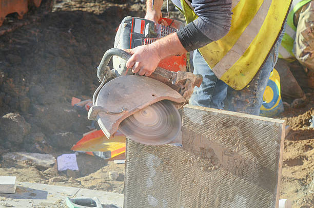 istock Construction worker using a concrete saw to cut concrete paving slab 2252654996