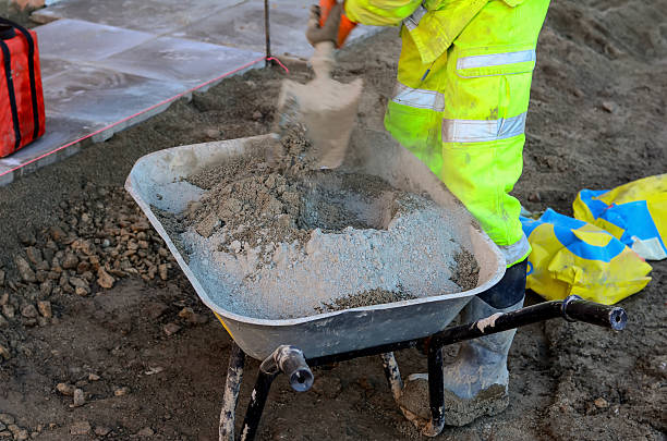 istock Construction worker mixing sand and cement in wheelbarrow for paving slab installation 2252655262