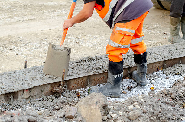 istock Builder pours concrete on construction site using shovel and wearing safety gear suitable for heavy-duty tasks 2252655266