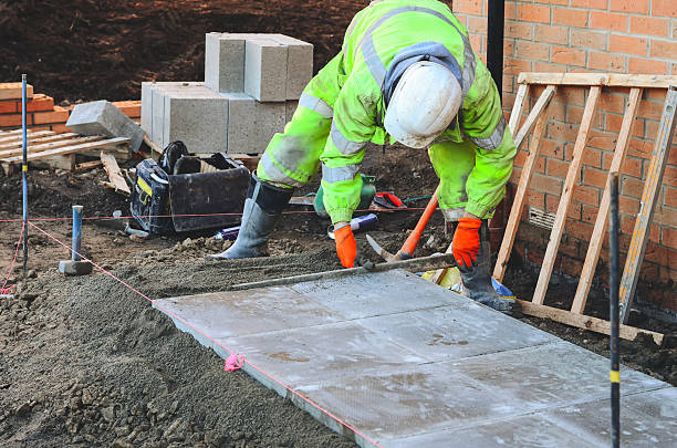 istock Construction worker laying concrete paving slabs at building site 2252655267