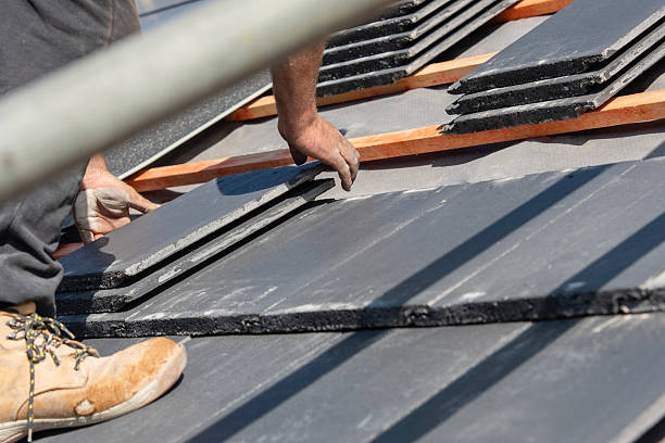 istock Skilled roofer installing slate tiles on residential roof 2252660908