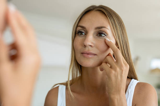 istock Woman Checking Skin Around Eyes in Mirror 2252661047