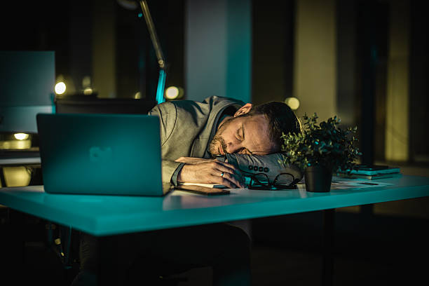 istock Business professional resting at desk during late night work hours in a modern office setting 2252661184