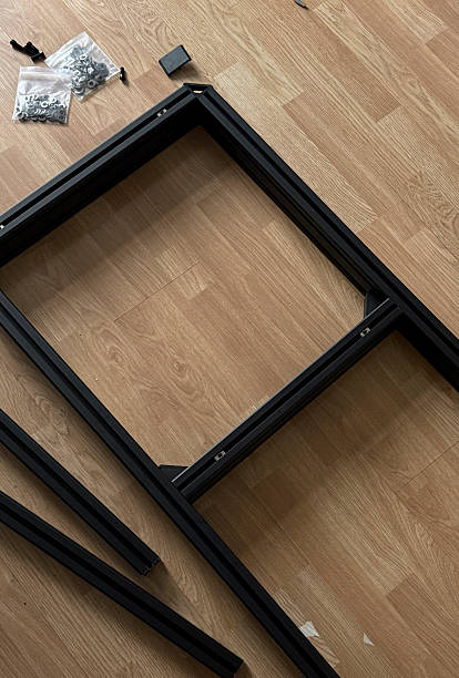 istock Assembling a black metal table frame with various parts scattered on a wooden floor in daylight 2252662921