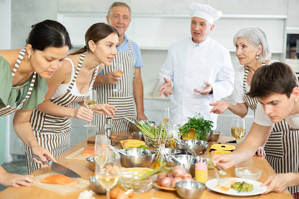 istock Cheerful woman drinking wine and talking during group culinary masterclass 2252667053