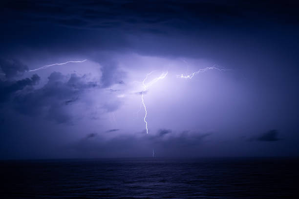Powerful lightning breaking through dense clouds at night, highlighting the raw energy and intensity of a nighttime thunderstorm
