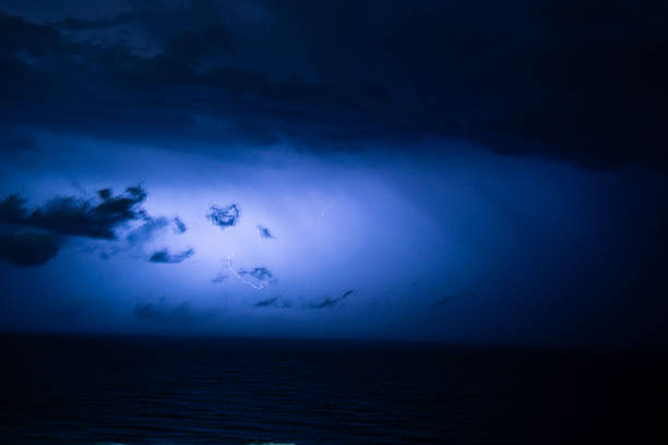 Powerful lightning breaking through dense clouds at night, highlighting the raw energy and intensity of a nighttime thunderstorm