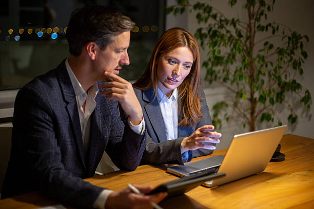istock Business colleagues collaborating on laptop late at night 2252679961