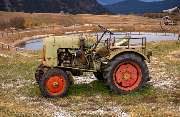 Vintage tractor on alpine pasture with mountain landscape