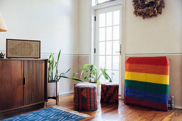 Bright, minimal interior with a rainbow pride flag draped over furniture, representing inclusivity, diversity, and LGBTQ identity within a calm residential or community space.