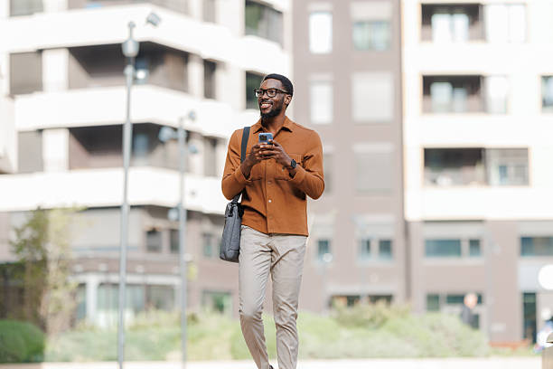 istock Young African American man walking outdoors with phone 2252684627